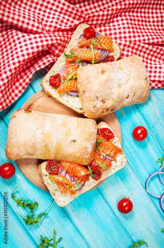 sandwich with smoked salmon on blue wooden table photo