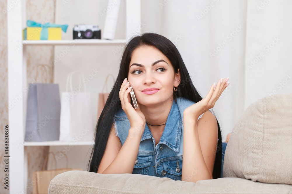 Young woman lying relaxing on comfortable couch using smart phone Young woman lying relaxing on comfortable couch using smart phone