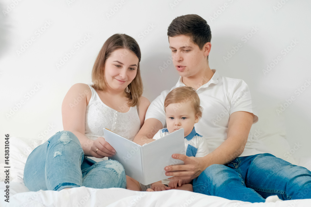 happy loving family. pretty young mother and ded reading a book to her daughters happy loving family. pretty young mother and ded reading a book to her daughters