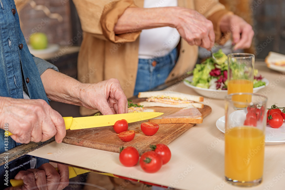 Cheerful mature friends cooking together Cheerful mature friends cooking together