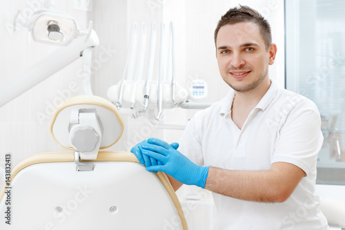 Professional male dentist posing in his clinic