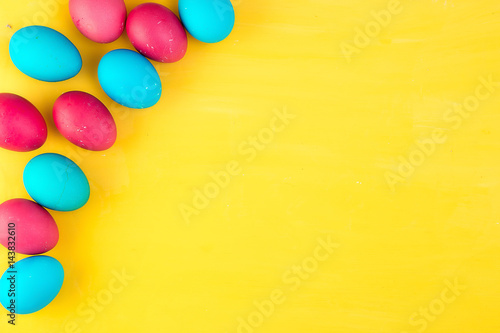 Colored easter eggs and willow on colored background