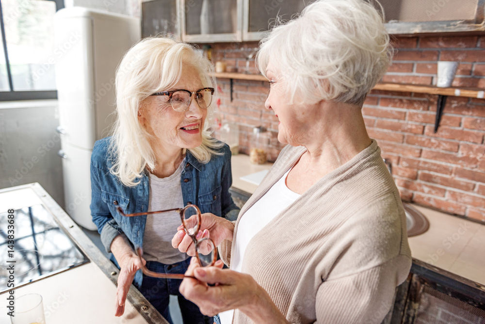 Joyful two grandmothers talking with excitement Joyful two grandmothers talking with excitement