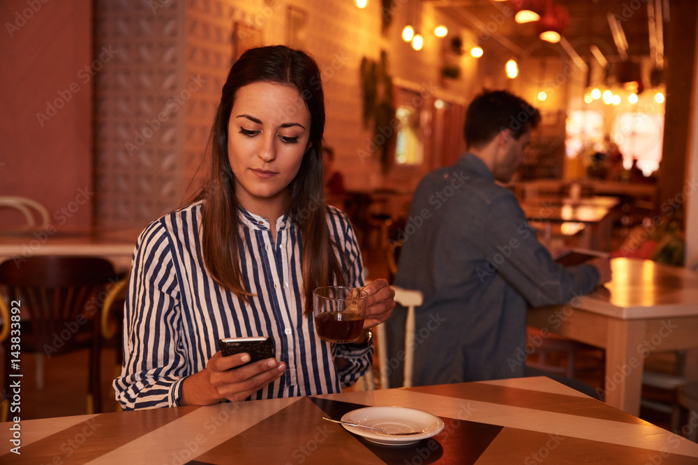 Millennial holding her tea and cellphone