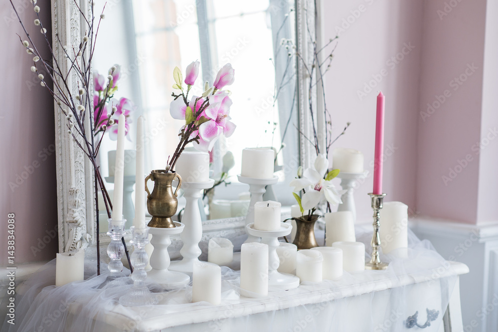 Shabby chic home design. Beautiful decoration table with a candles, flowers in front of a mirror