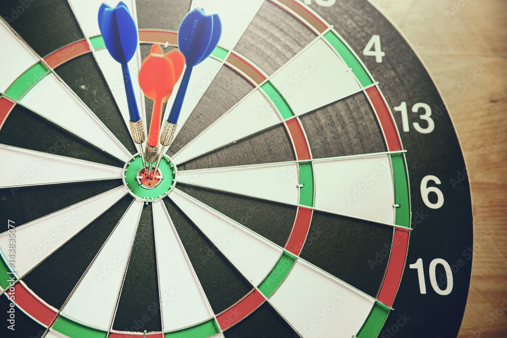 Dart arrow hitting in the target center of dartboard Dart arrow hitting in the target center of dartboard