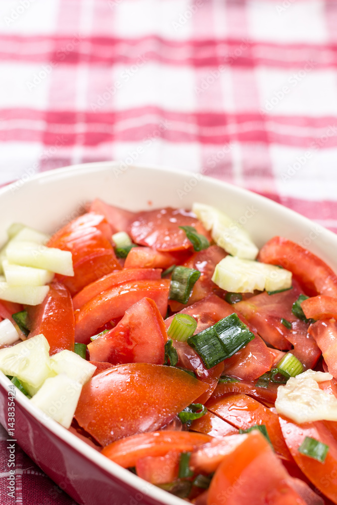 Sliced tomato with young onions salad on the table