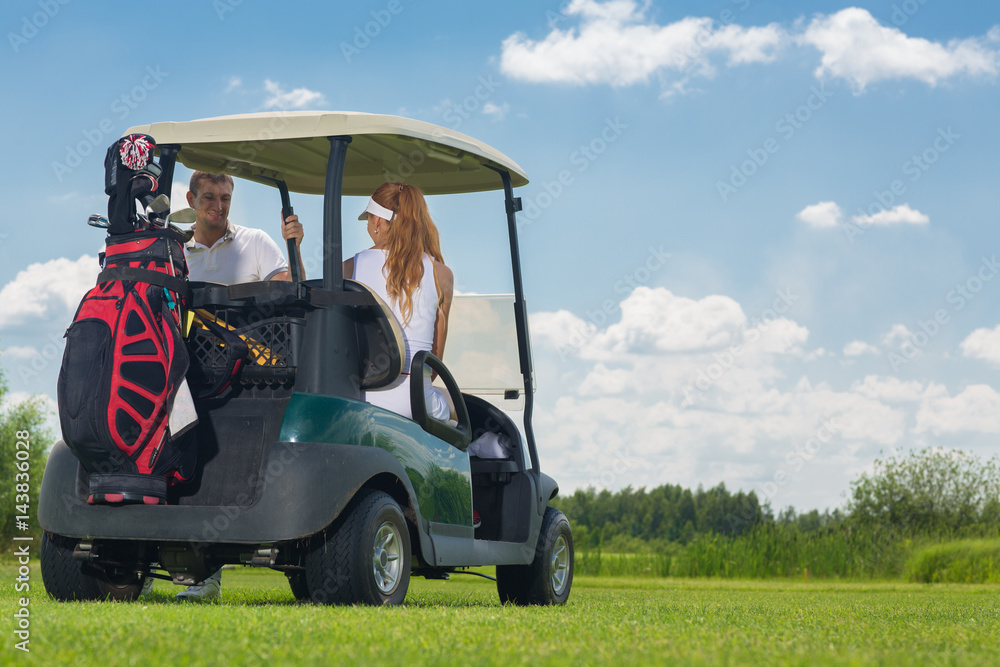 Young couple driving a golf cart