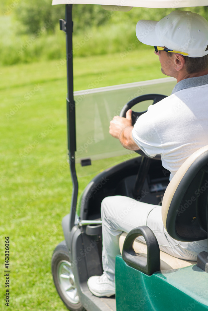 Male golfer in a golf cart Male golfer in a golf cart