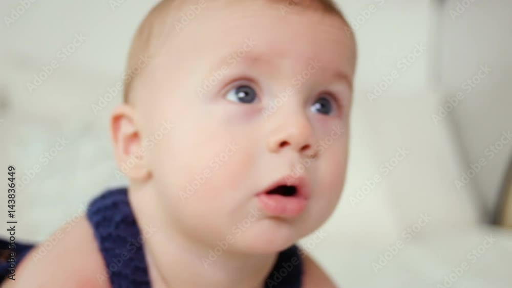 little baby boy of five months, crawling on the floor in the blue knit jumpsuit little baby boy of five months, crawling on the floor in the blue knit jumpsuit