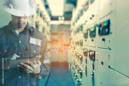 Double exposure of  Engineer or Technician man   working with tablet in switch gear electrical room of oil and gas platform or plant industrial for monitor process, business and industry concept