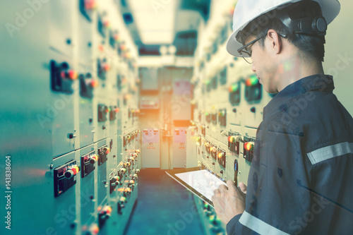 Double exposure of  Engineer or Technician man  working with tablet in switch gear electrical room of oil and gas platform or plant industrial for monitor process, business and industry concept