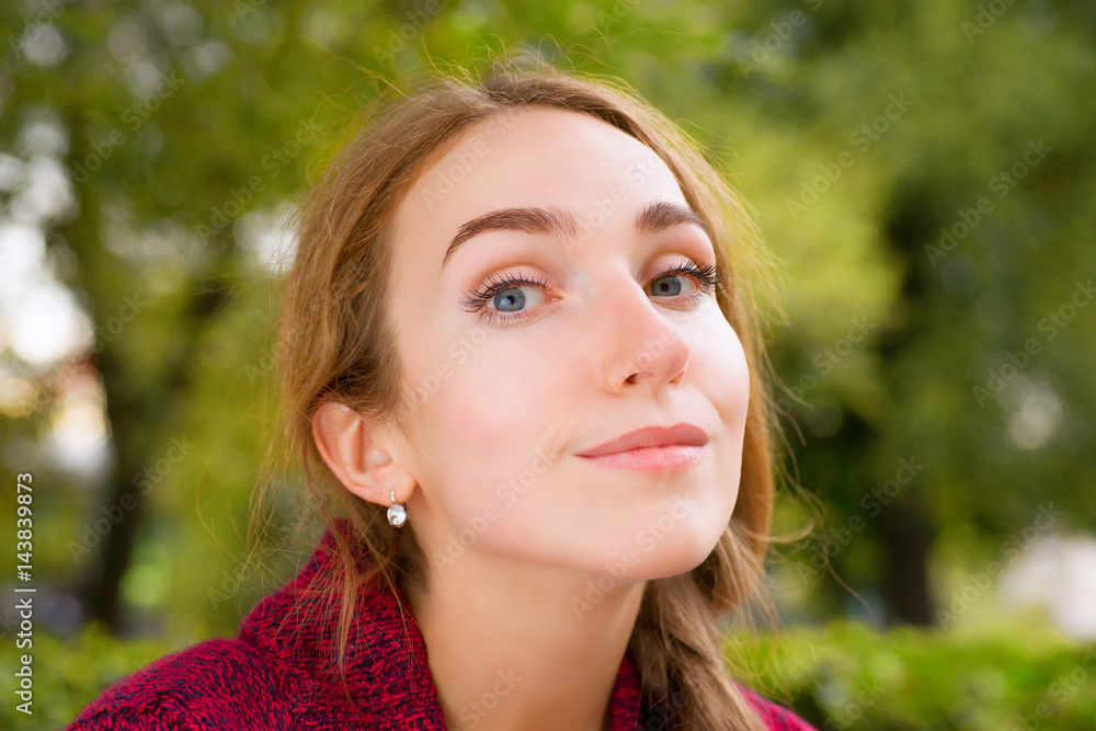 Young smiling woman against green foliage Young smiling woman against green foliage