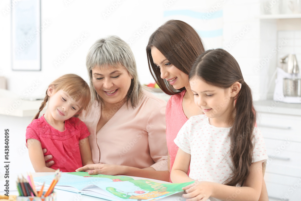 Family with book sitting at kitchen table Family with book sitting at kitchen table