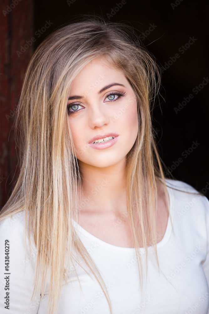 Senior photo of a young woman on a farm wearing farm style clothing Senior photo of a young woman on a farm wearing farm style clothing