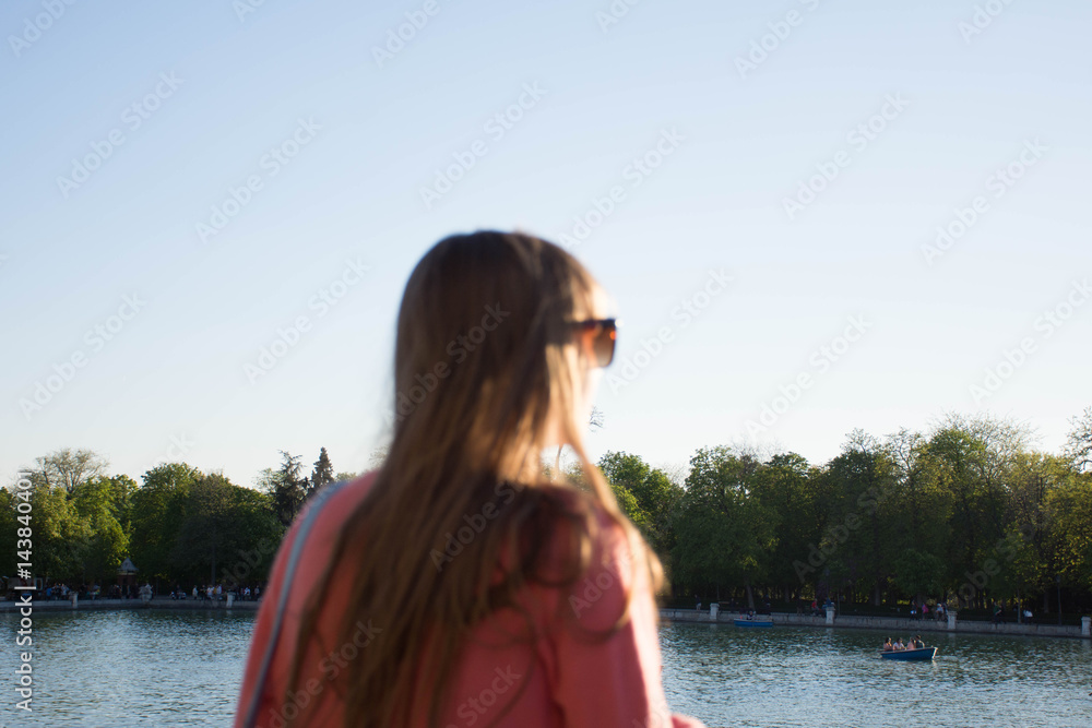 Girl looking at the lake in a blurred plan