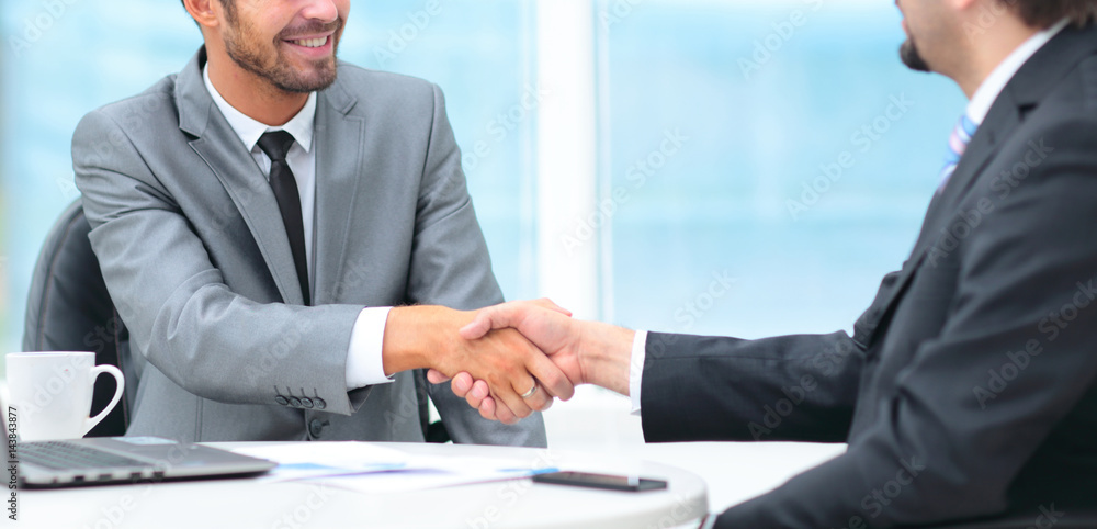 Two business people shaking hands with each other in the office Two business people shaking hands with each other in the office