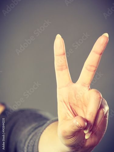 Female hand shows victory symbol. photo