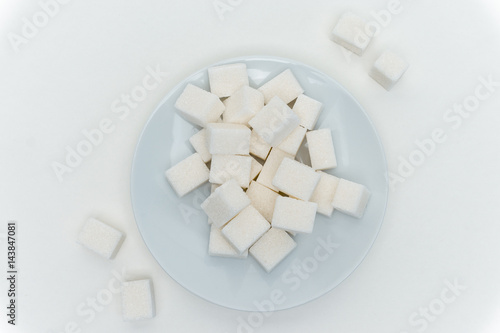 sugar cubes in a plate on a light background