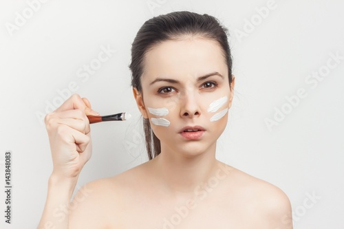 white lines on woman's face, make-up brush