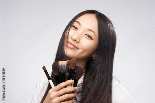 make-up brushes, dark hair, a woman with Korean appearance