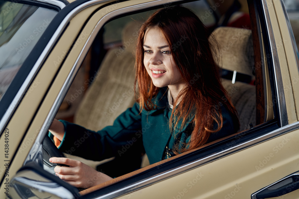 attractive woman sits at the wheel of a car and looks at the road