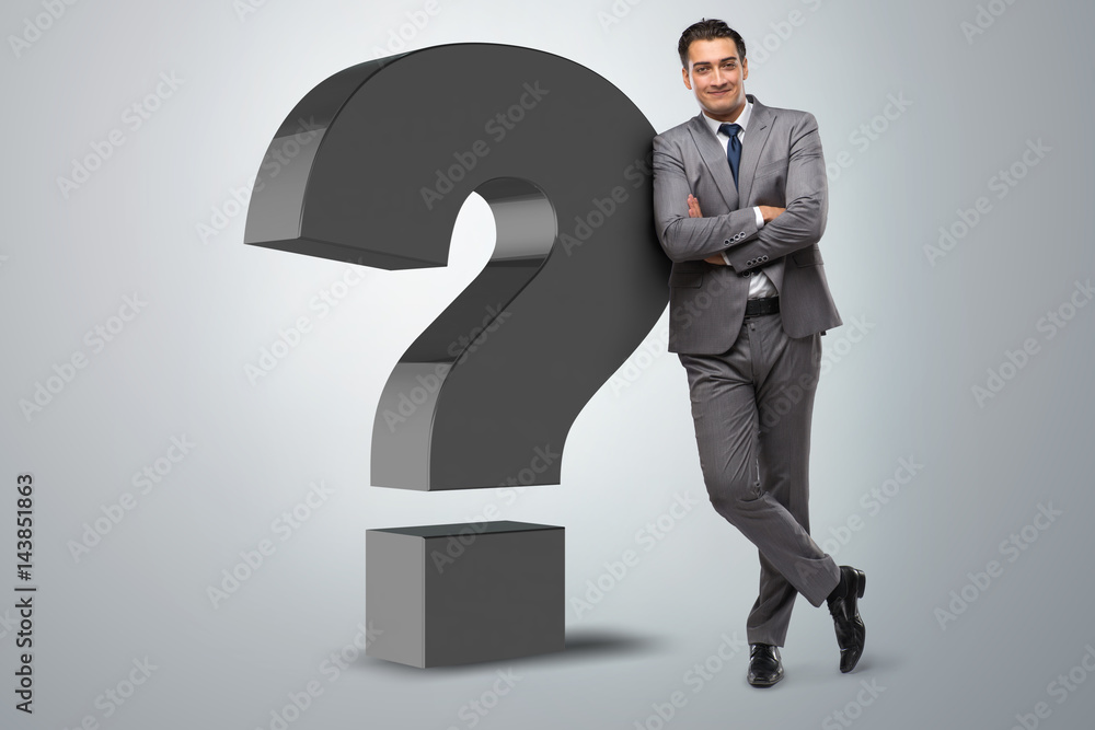 Businessman next to the giant question mark