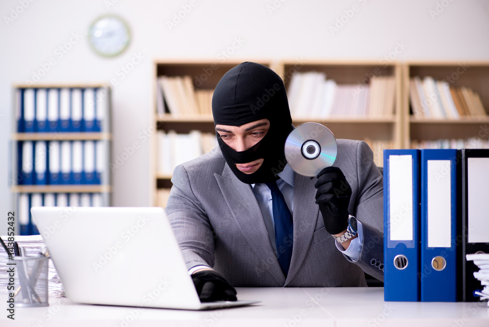 Criminal businessman wearing balaclava in office