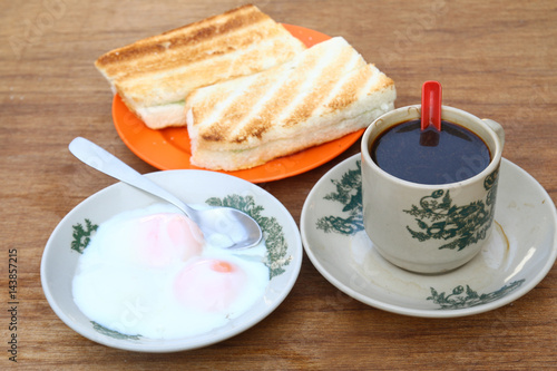 Breakfast set of half boiled eggs, toast and coffee, popular meal in Malaysian and Singaporean coffeeshops