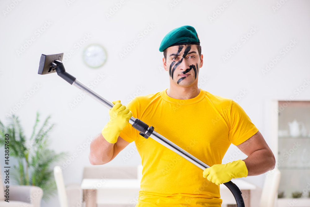 Funny man in military style cleaning the house Funny man in military style cleaning the house