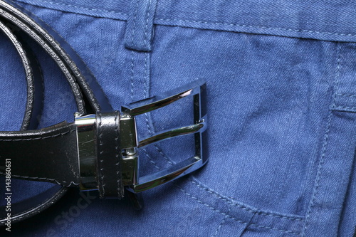Blue color of short trouser made from herringbone patterned fabric style represent the applied synthetic cloth production in the scene appear the black color leather belt business style also.