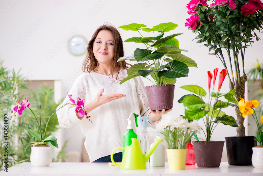 Young woman looking after plants at home