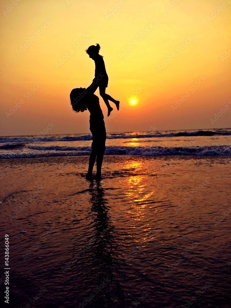 mother and child silhouette in the beach sunset