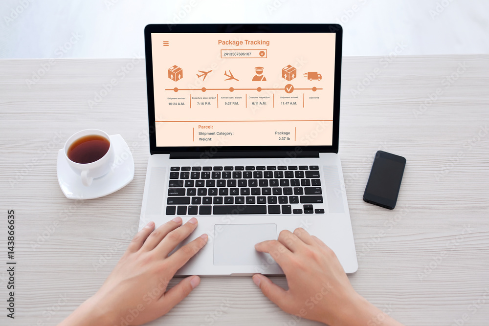 male hands typing on laptop keyboard with package delivery tracking male hands typing on laptop keyboard with package delivery tracking