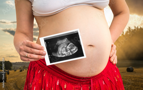 Belly of a pregnant woman and ultrasound scan of baby photo