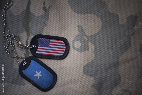Foto army blank, dog tag with flag of united states of america and somalia on the khaki texture background