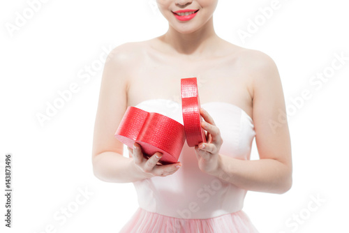 Happy beautiful young woman opening heart shape red gift box