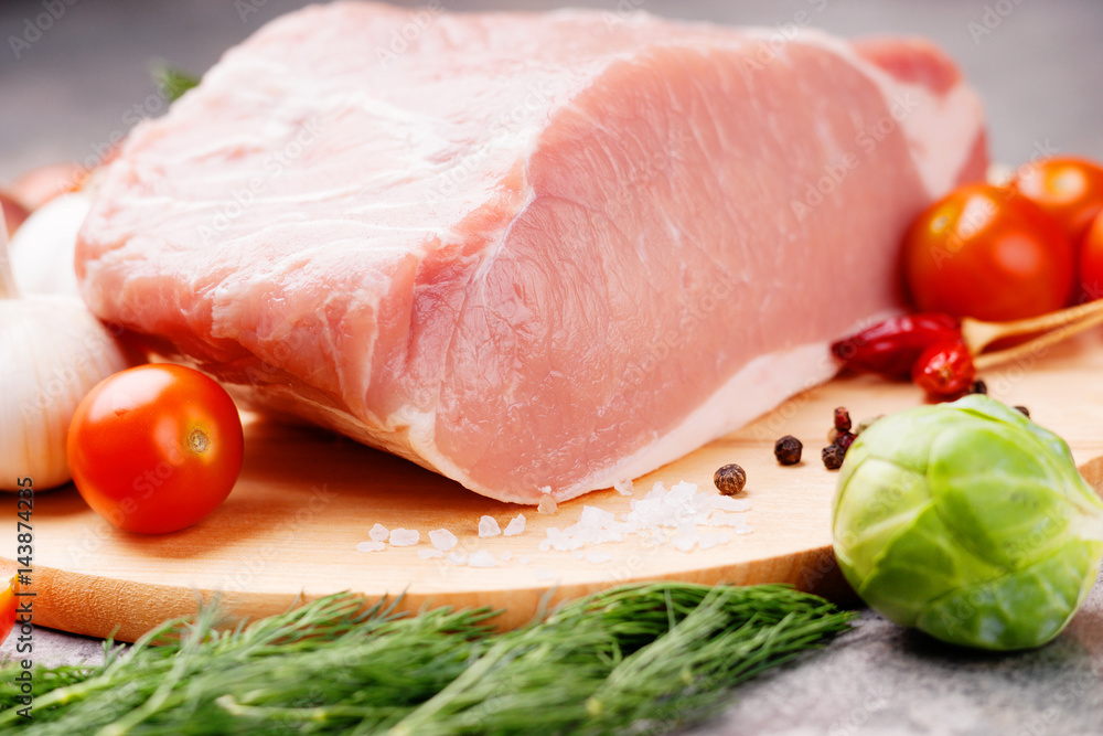 Raw pork on cutting board and vegetables Raw pork on cutting board and vegetables