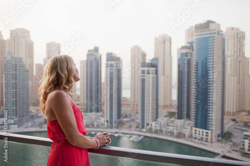 Woman looking out from balcony.