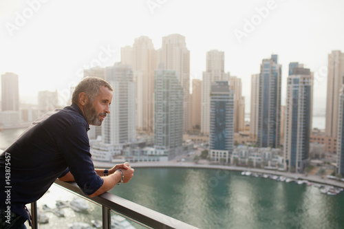 Expat man leaning at balcony. photo