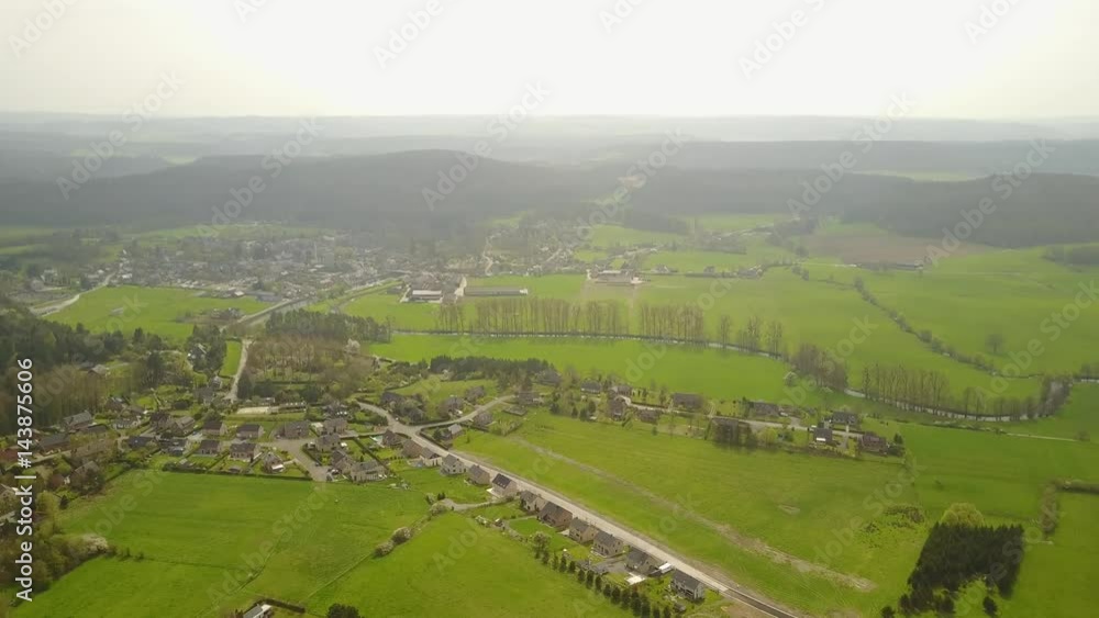 Aerial: flying over the agrarian hilly fields in La Roche Area with little village, Belgian Ardennes Aerial: flying over the agrarian hilly fields in La Roche Area with little village, Belgian Ardennes