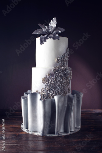 Large wedding cake decorated with beads and silver flower photo