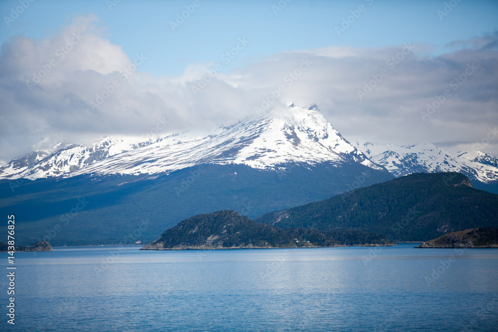 Tierra del Fuego, landscape of snowy and wooded mountains and ocean Tierra del Fuego, landscape of snowy and wooded mountains and ocean