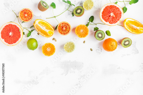 Fruit background. Colorful fresh fruit on white table. Orange  tangerine  lime  kiwi  grapefruit. Flat lay  top view  copy space