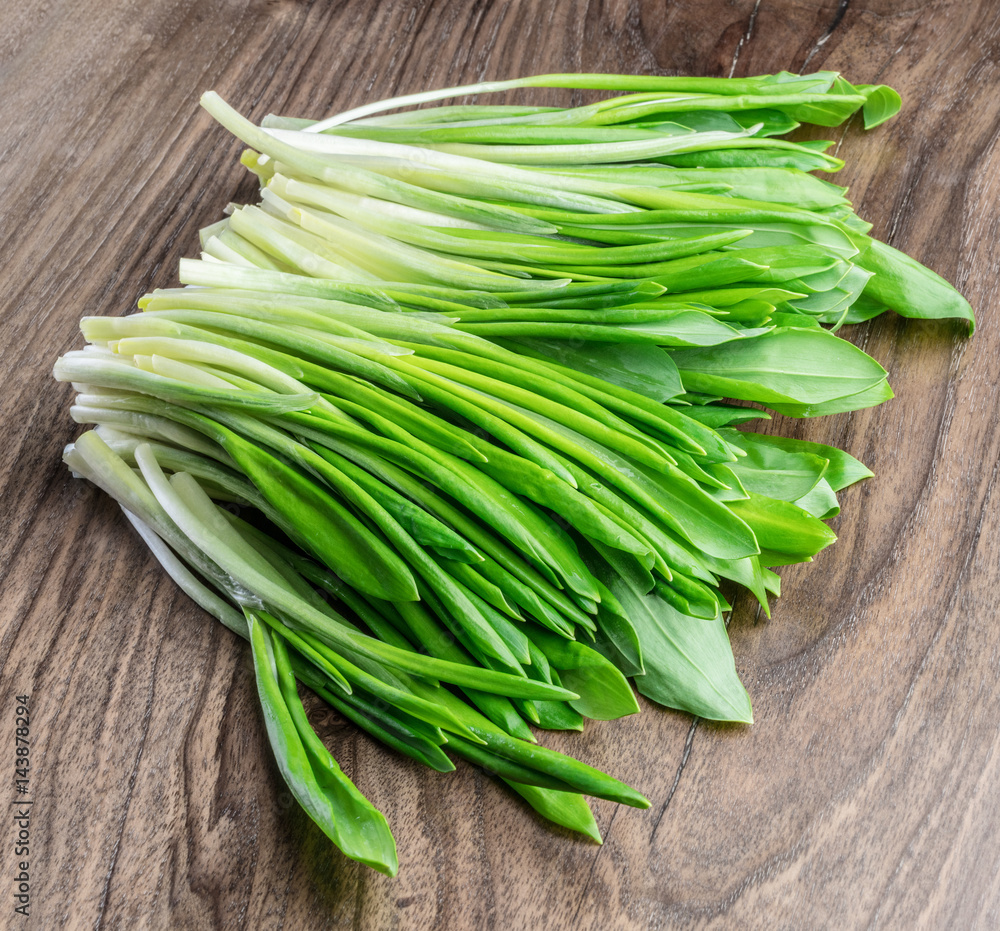 Young fresh wild garlic on the wooden table. Young fresh wild garlic on the wooden table.