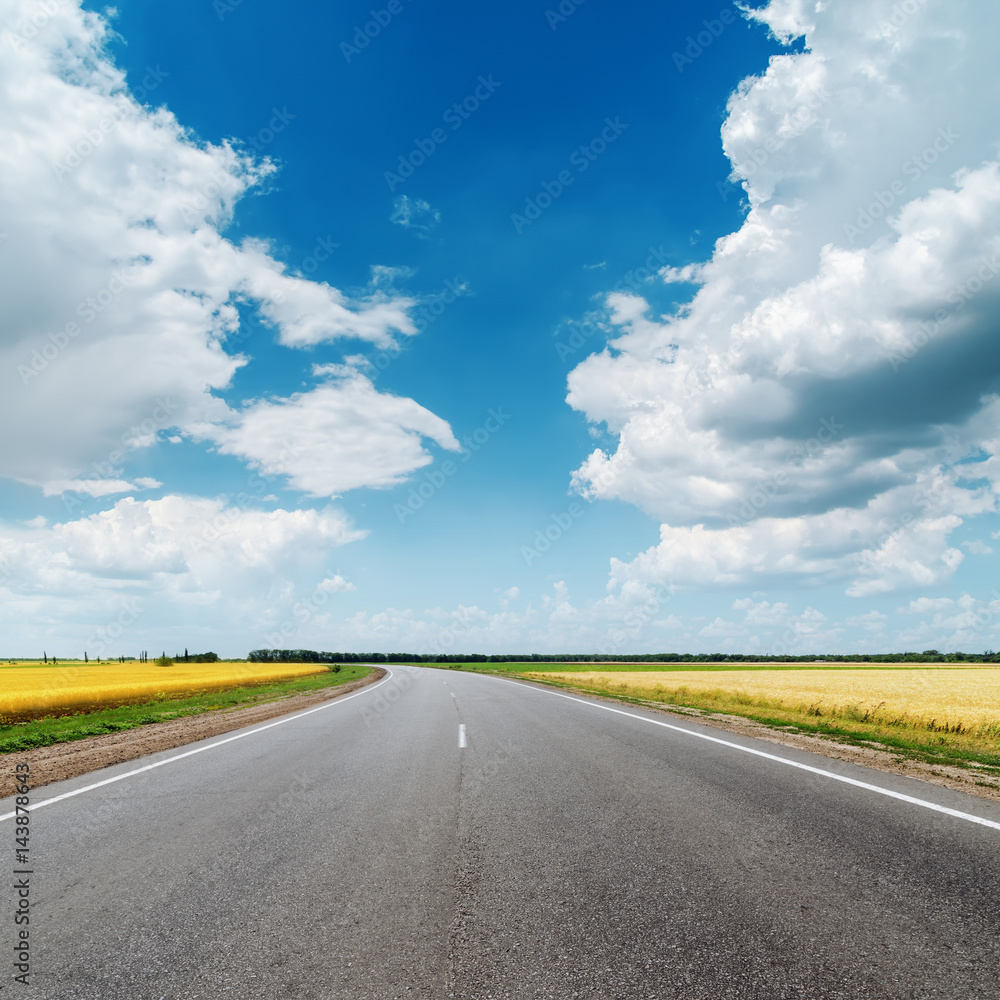 asphalt road under clouds in blue sky
