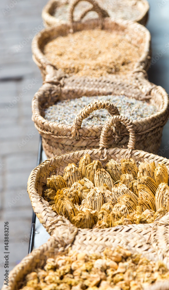 Dry herbs in handmade braided basket for sale on market