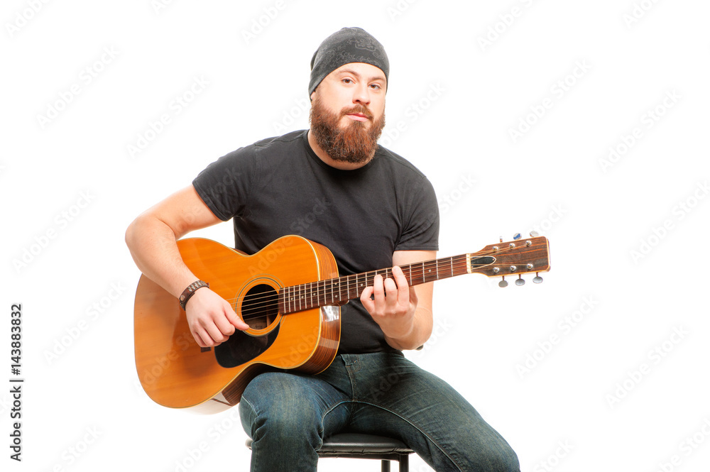 Stockfoto med beskrivningen Man playing guitar. Bearded young men sitting  and playing acoustic guitar over white | Adobe Stock