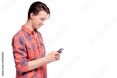 Youth and technology. Studio portrait of handsome young man using smart phone. Isolated on white.