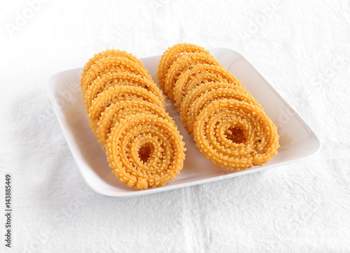 Chakli, also known as murukku, which is a south Indian traditional, popular and vegetarian snack, on a plate.